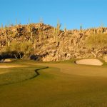 Green on the golf course at the Stone Canyon Club with rocky hills as scenery in Tucson Arizona