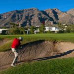 Skyline Country Club - Chipping out of a bunker in front of golf homes and the mountains in the Tucson Arizona golf community